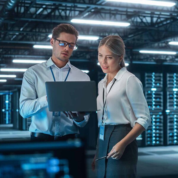 colleagues looking at a laptop in a data center